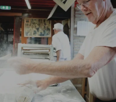 Bakker die deeg aan het kneden is bij Bakkerijmuseum Medemblik